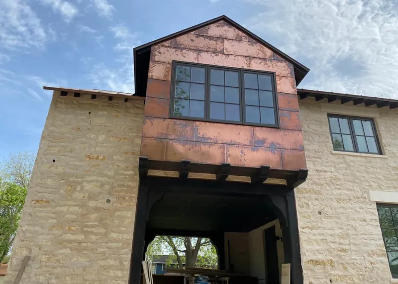 Copper metal panel facade on a stone building for Skylight Installation in Webster